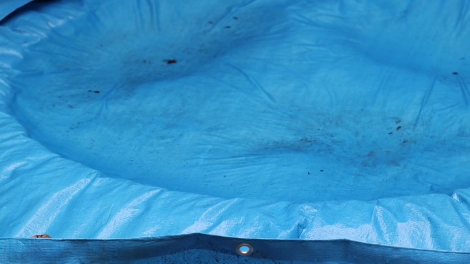 室外蓝色篷布，表面有雨水