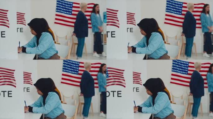 戴头巾的穆斯林妇女在选举区的投票站填写选票