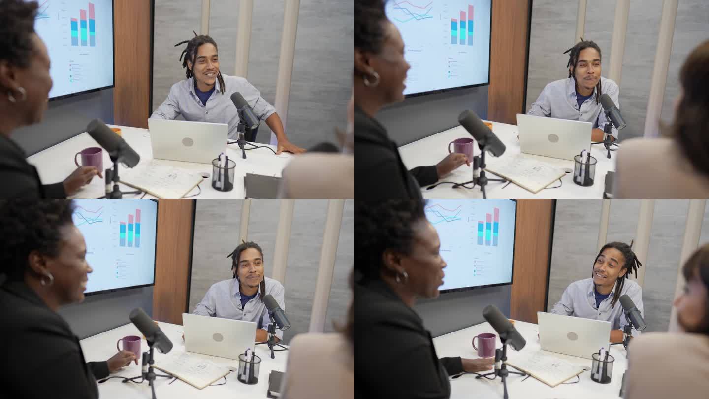 一个年轻人在录制播客节目时与同事交谈