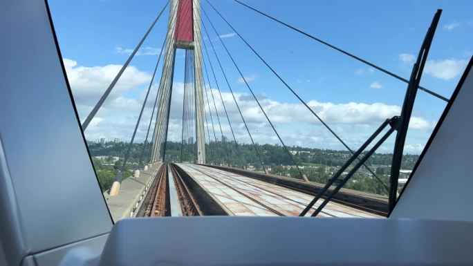 Skybridge TransLink后窗列车在桥上另一辆蓝色列车通过大城市的轻交通温哥华普通人工作