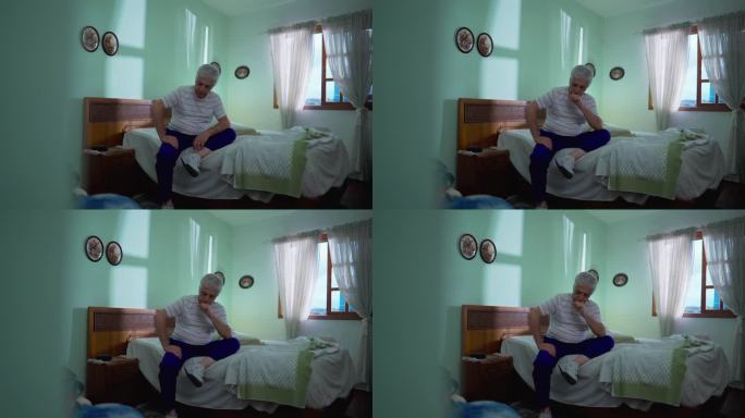 一位深思熟虑的老人坐在卧室的床边忧郁地沉思。老人的肖像描绘了老年，挣扎于困境，思考着抉择