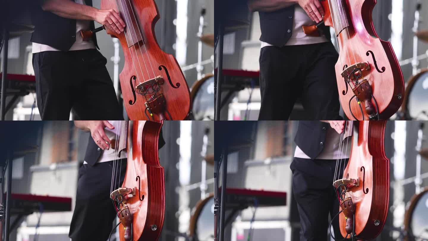 一名低音大提琴手与歌手和音乐摇滚乐队的音乐会视图，在爵士乐队乐队表演音乐，大提琴手大提琴爵士手在舞台
