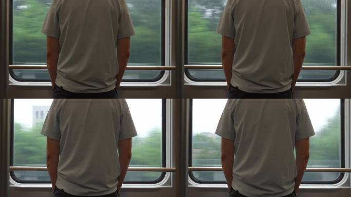 一个男人站在火车上看着窗外