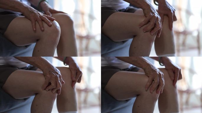 一个资深女性揉揉和按摩膝盖的特写镜头，可能是为了缓解不适或缓解僵硬