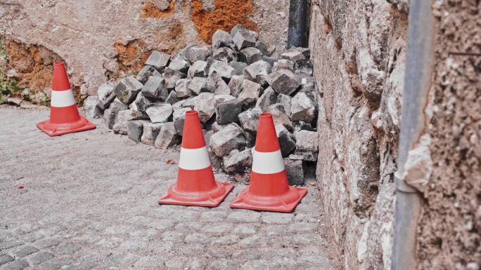 历史悠久的意大利古城建筑改造遗址，用红色道路锥标记和保护砖和瓦砾