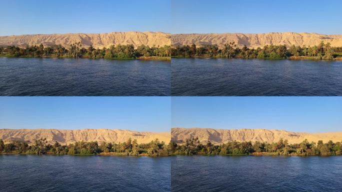 尼罗河两岸，背景是植被和沙漠山脉。视差效果。鸟瞰图。尼罗河。埃及。