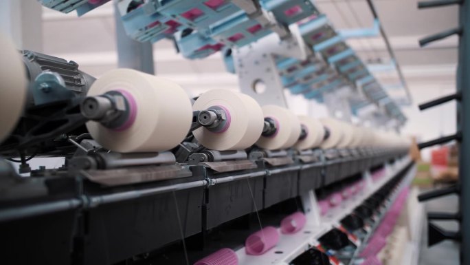 意大利，科萨托，2022年4月17日:特写的纱线线轴。纺织厂设备。纺织工厂。纺纱生产。纱线制作工艺。