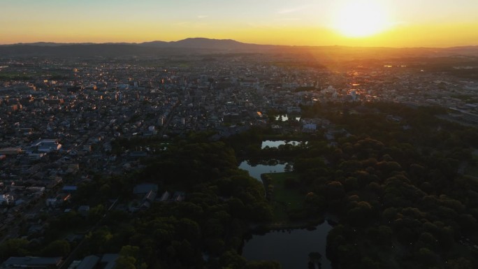 无人机跟踪拍摄奈良公园与阳光城市背景，日落在日本
