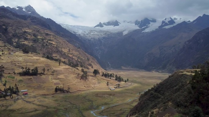 普卡吉尔卡山峰和冰川的相机移动侧面小山丘和山谷阴天航拍视频