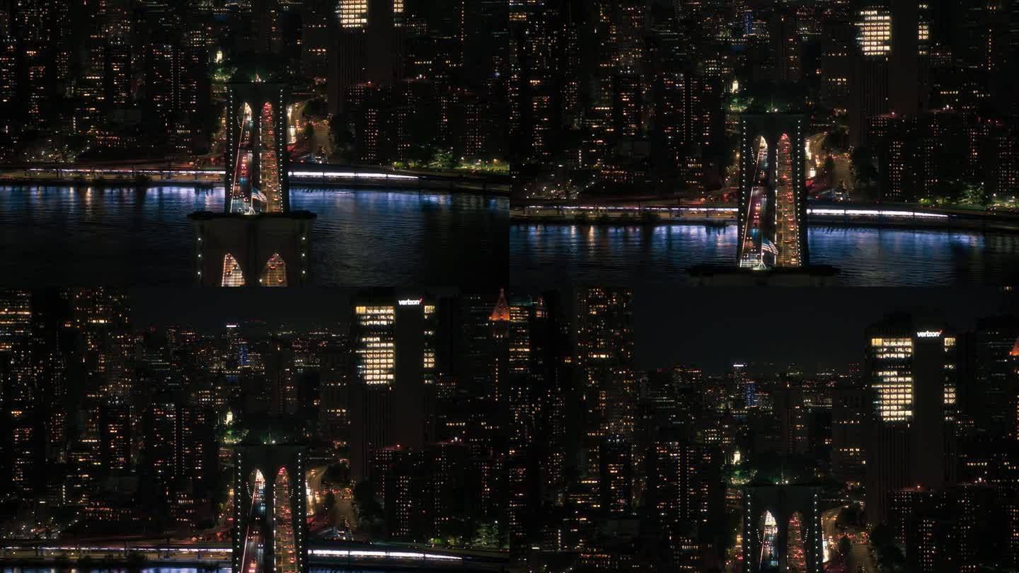 空中直升机电影夜景与布鲁克林大桥的俯视视图切换到全景拍摄与摩天大楼的城市景观。美丽的办公大楼在黑暗中