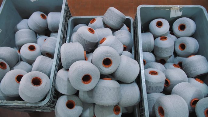 篮子里的一捆捆纱线。线生产。纺织工厂。纺纱生产。纱线制作工艺。纺织厂设备。