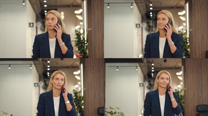 穿着正装的漂亮商务女士在办公室外面打了个电话。戴着手表的蓝眼睛微笑的女人在现代智能手机上愉快地交谈。