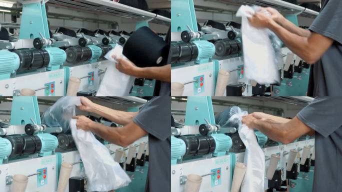 一名工人正在打包成卷的纱线。纺织厂设备。纺织工厂。纺纱生产。纱线制作工艺。线生产。