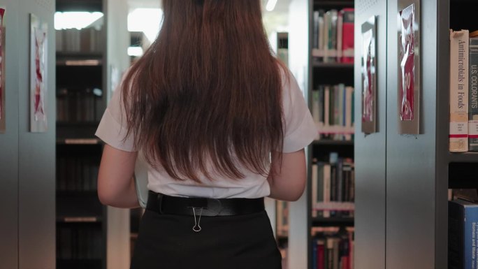 一个年轻的学生正在图书馆里找东西