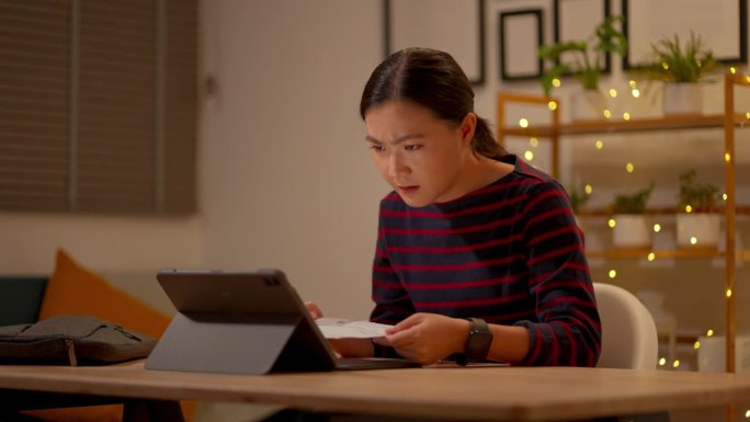 使用平板电脑和信用卡的亚洲女性在支付方面感到困惑。