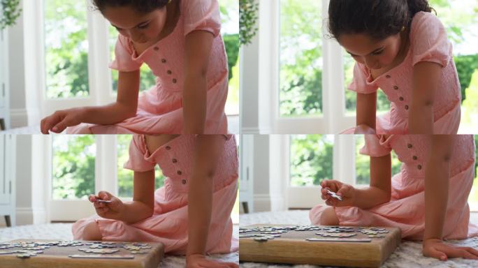 小女孩坐在客厅地板上玩拼图游戏的特写