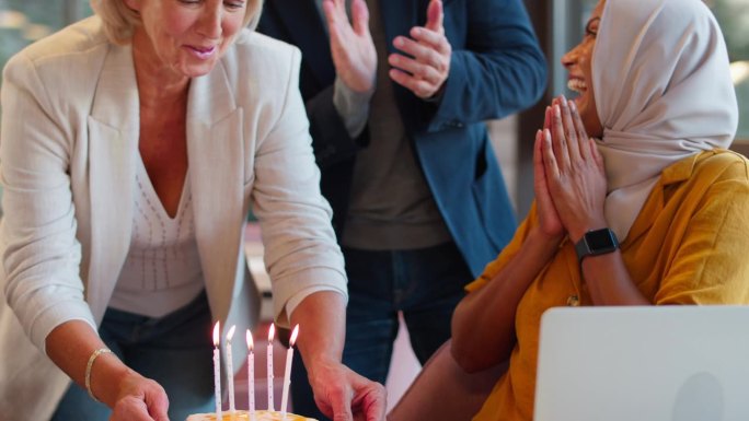 员工用蛋糕庆祝戴头巾女同事生日
