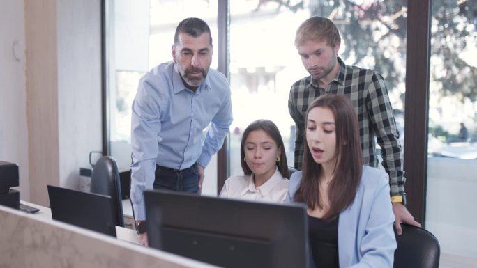 成功的商业团队在办公室工作。在电脑屏幕前进行头脑风暴和提供建议。同事解决工作任务问题。