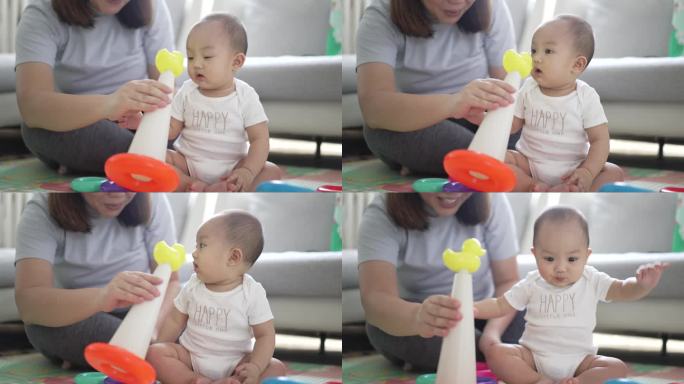 妈妈带着8个月大的小男孩在家里玩着五颜六色的玩具，玩得开心又有趣