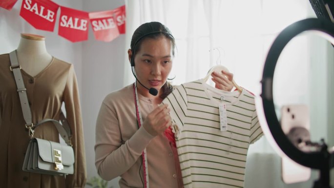 女人直播销售时尚服装在家里