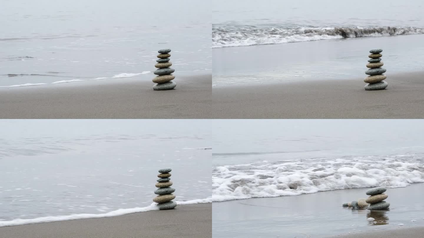 海岸上的石头金字塔被来袭的海浪冲垮了。对平衡的破坏。