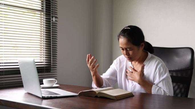 一位女基督徒每天早上上班前在办公室祷告，以信靠神。