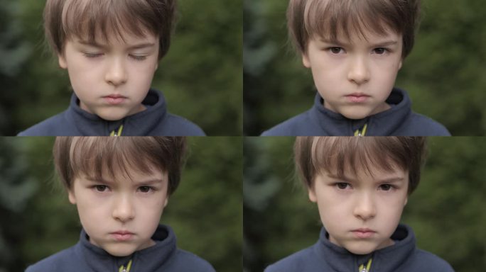 悲伤的小男孩看着相机。思考好奇的孩子看相机近距离户外。忧郁的脸，严肃的眼睛，沉思的孩子。童年时期的消