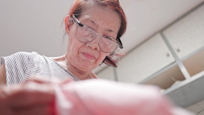 年长的亚洲女性喜欢缝纫作为一种爱好
