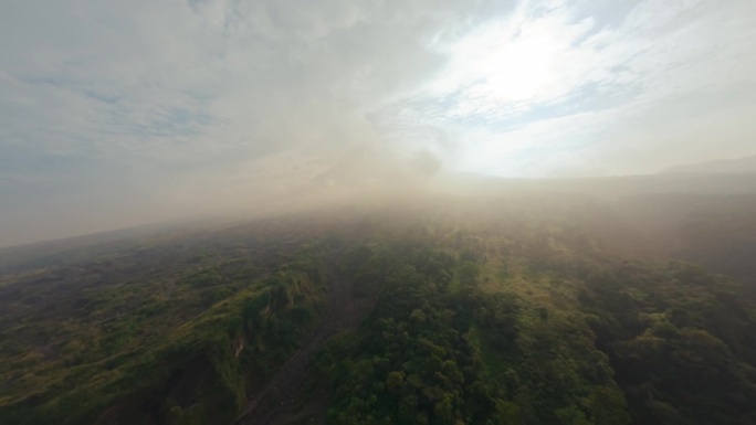 峡谷干涸的河流之间覆盖着绿植巨大的火山喷发山峰