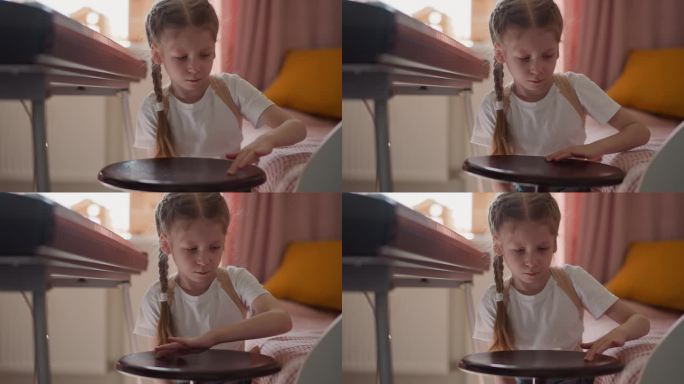 冷静的小女孩把钢琴凳合成器钢琴