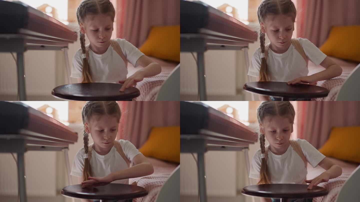 冷静的小女孩把钢琴凳合成器钢琴