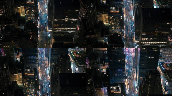 广告牌上的霓虹灯照亮了纽约市街道的鸟瞰图。繁忙的都市交通，汽车，黄色出租车，商用车辆和步行的人