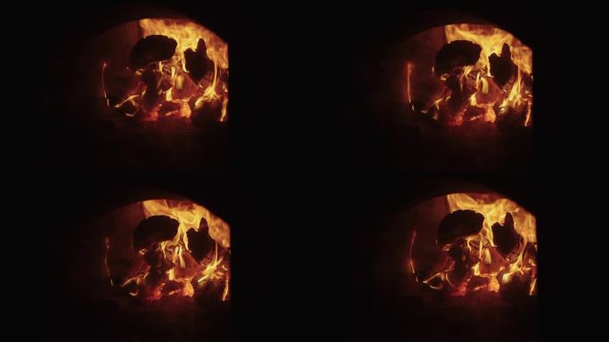 在炉中燃烧原木，黑暗中鲜红和黄色的火焰，用柴火取暖