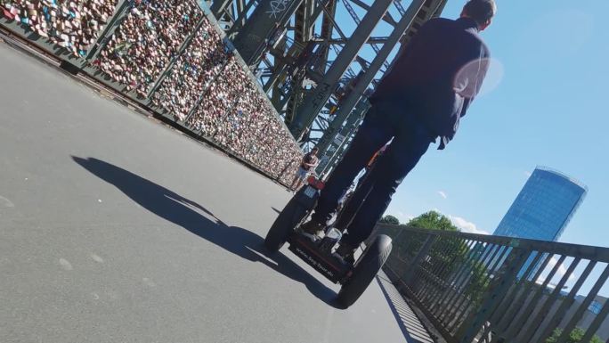 游客驾驶赛格威或悬浮滑板。德国科隆霍亨索伦桥上的自平衡电动滑板车，慢动作