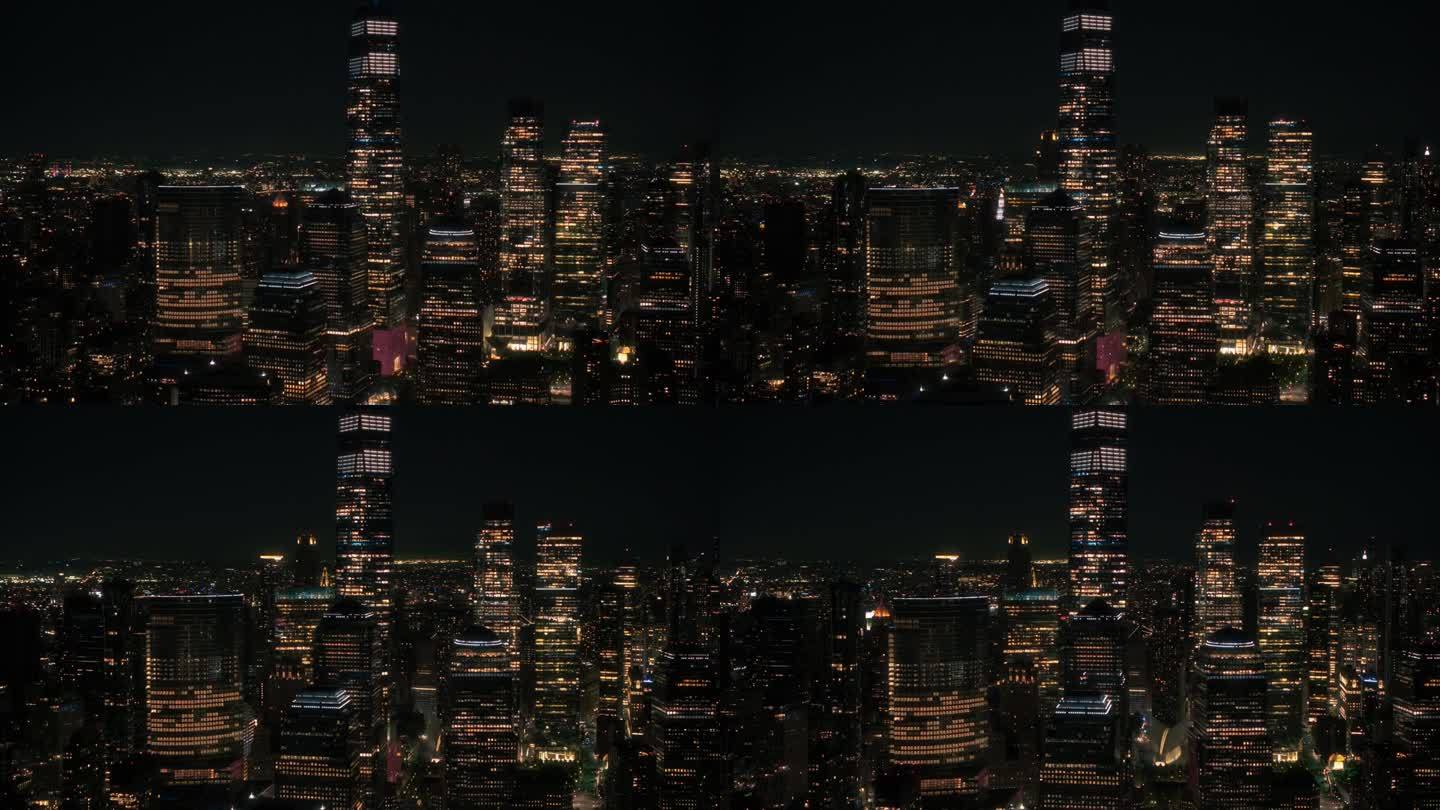 空中直升机电影夜景全景与一个世界贸易中心摩天大楼和充满活力的城市景观。带有室内灯光的美丽办公大楼
