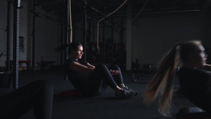 团体健身班，女性在健身房训练，在地板上做腹肌练习，健康锻炼