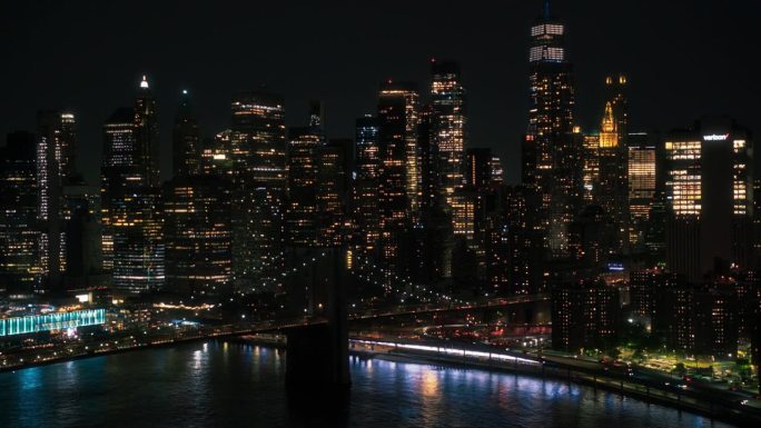 纽约市中心夜景。曼哈顿下城和布鲁克林大桥鸟瞰图。有摩天大楼的电影城市景观，有灯光的办公楼，有汽车和交