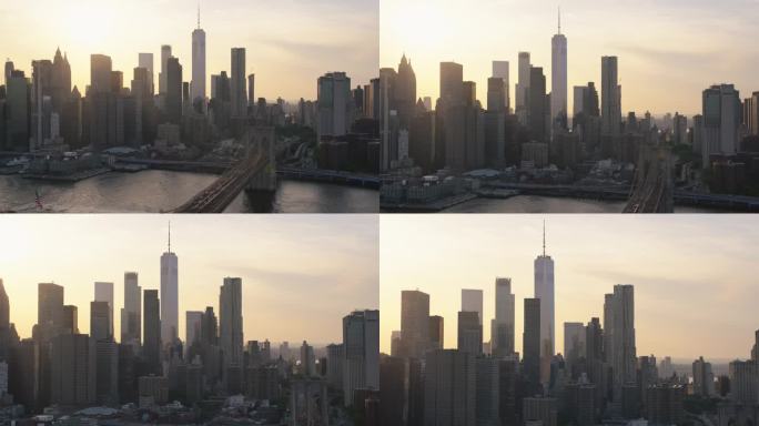 空中直升机电影场景在布鲁克林大桥与曼哈顿摩天大楼的城市景观。美丽的晚霞闪耀着温暖的晚霞。聚焦世贸中心