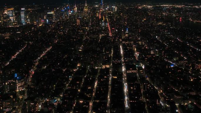 航拍超高速夜间镜头穿过曼哈顿下城与办公大楼的夜晚。华尔街、帝国大厦和时代广场的移动延时锁