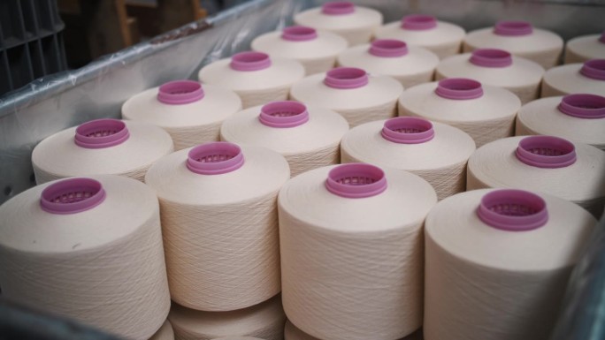 近距离的纱线线轴。纺织工厂。纱线制作工艺。线生产。纺纱生产。纺织厂设备。