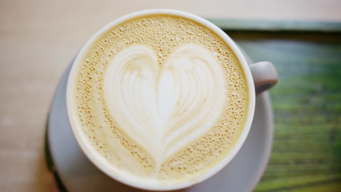 一个画着心形的咖啡泡沫的近距离垂直视图