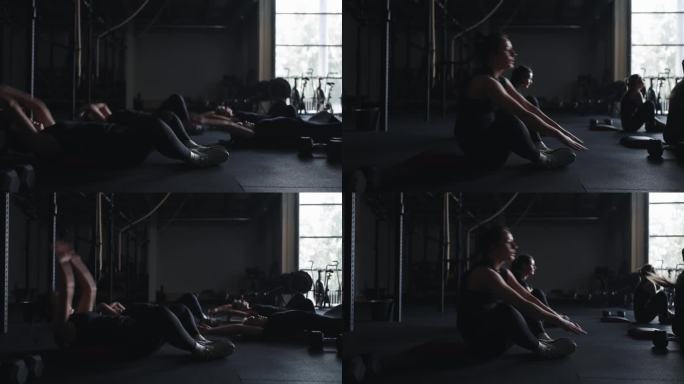 健身中心集体体育课，女性在健身房训练，在地板上做腹肌练习