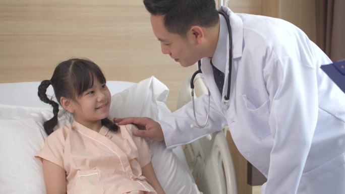 亚洲男医生和女护士交谈和安慰一个生病的小女孩