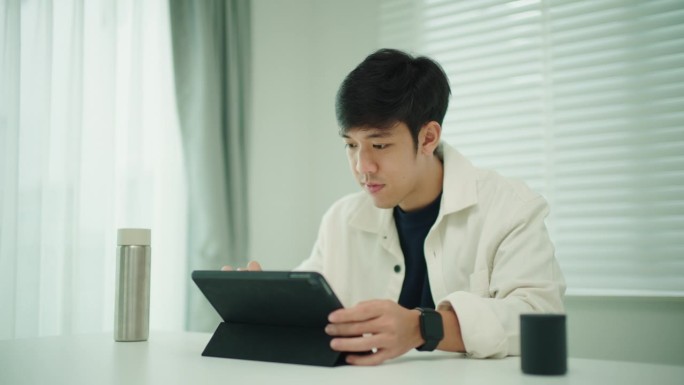 男子使用数码平板电脑和蓝牙扬声器。