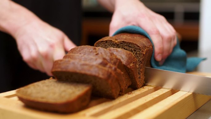 刚烤好的面包框，切在木板上。一块面包，一块食物，健康饮食理念。