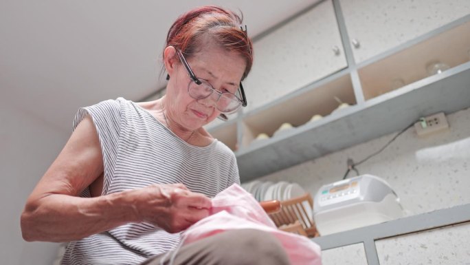 年长的亚洲女性喜欢缝纫作为一种爱好