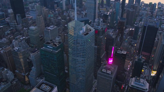 傍晚纽约市空中景观，曼哈顿中城摩天大楼和彩色照明时代广场。电影无人机视图与日落下的城市景观