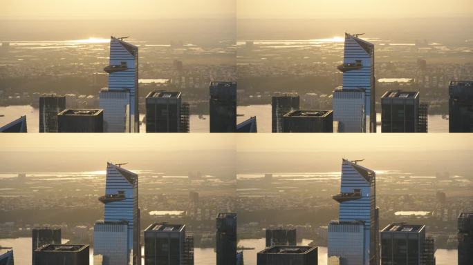 曼哈顿天际线上方的直升机镜头，聚焦于30哈德逊广场摩天大楼的外部观景台。一群游客在观景台上欣赏城市日