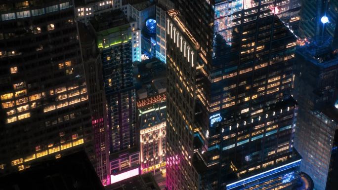 夜景纽约直升机之旅。飞越灯火通明的曼哈顿办公室和大城市里挤满汽车和出租车的街道。有粉红色霓虹灯广告牌