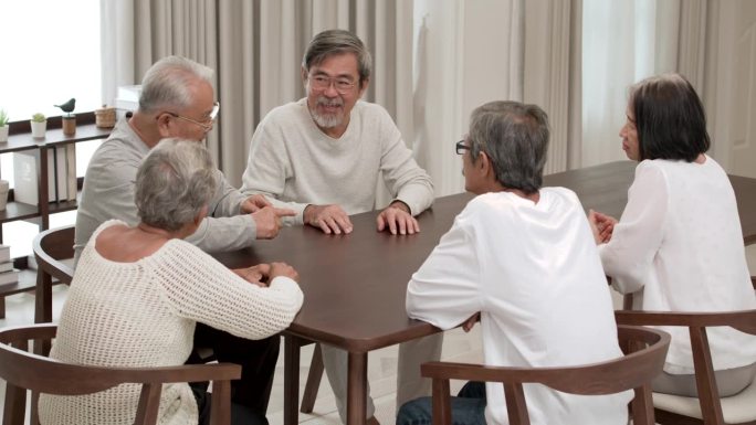 一群快乐的亚洲老年男女微笑着分享经验。